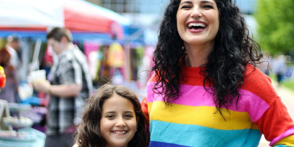 Mother wearing rainbow-coloured shirt with child